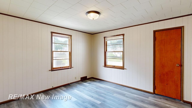 508 Malzahn St, Saginaw, MI 48602 - empty room featuring crown molding, wood finished floors, and wooden walls