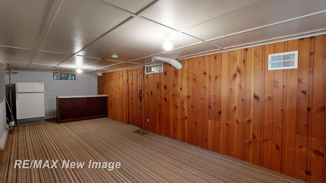 508 Malzahn St, Saginaw, MI 48602 - finished below grade area featuring freestanding refrigerator, concrete block wall, wood walls, and carpet flooring