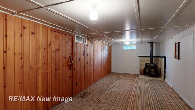 508 Malzahn St, Saginaw, MI 48602 - basement featuring a wood stove, carpet floors, and wooden walls