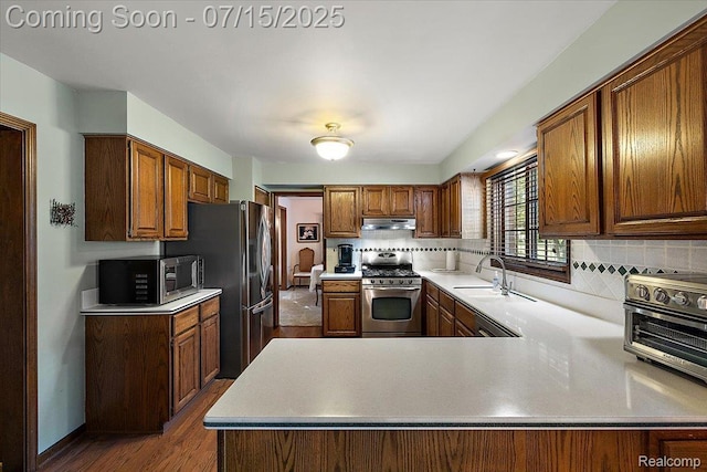 4516 Cahill Dr, Troy, MI 48098 - kitchen featuring stainless steel appliances, backsplash, light countertops, dark wood-type flooring, and a peninsula
