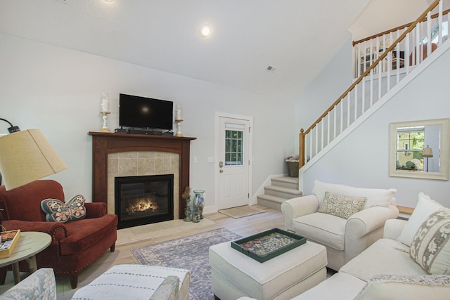 488 Solace Way S, Haven, MI 49090 - living room featuring stairs, healthy amount of natural light, high vaulted ceiling, a tile fireplace, and wood finished floors