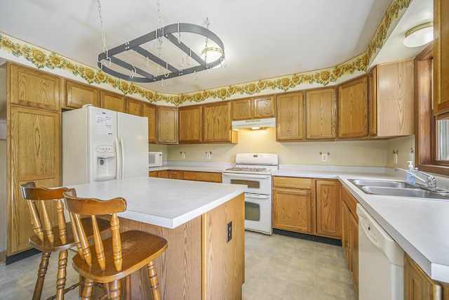 131 E Ave, Jackson, MI 49201 - kitchen with white appliances, under cabinet range hood, light floors, and light countertops