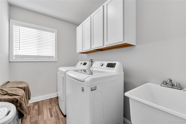 343 Hidden Riv E, Holly, MI 48442 - laundry room featuring independent washer and dryer, cabinet space, and wood finished floors