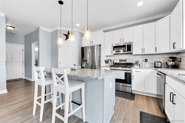 343 Hidden Riv E, Holly, MI 48442 - kitchen with stainless steel appliances, light wood-style floors, backsplash, white cabinets, and crown molding
