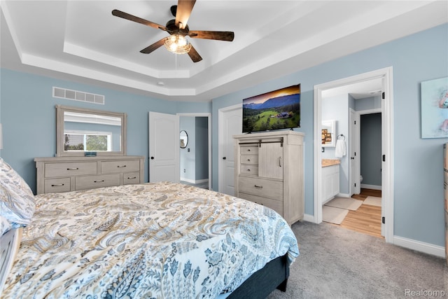 343 Hidden Riv E, Holly, MI 48442 - bedroom featuring a raised ceiling, light carpet, ceiling fan, and connected bathroom