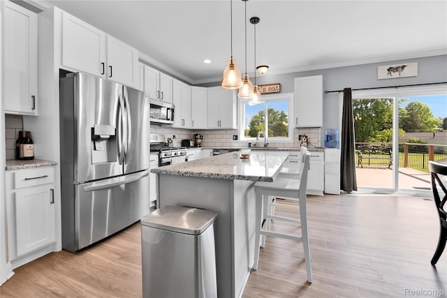 343 Hidden Riv E, Holly, MI 48442 - kitchen featuring stainless steel appliances, healthy amount of natural light, decorative backsplash, white cabinetry, and ornamental molding