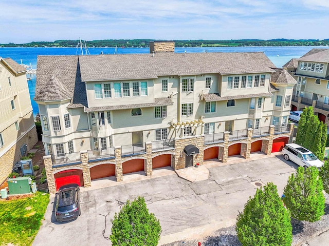 706 N Dockside Cir, Suttons Bay, MI 49682 - view of property with an attached garage, driveway, and a water view