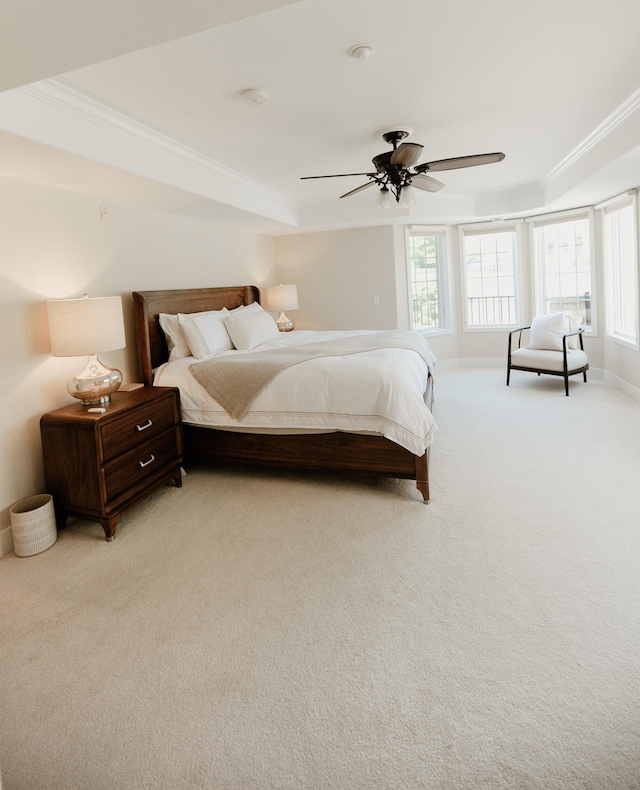 706 N Dockside Cir, Suttons Bay, MI 49682 - bedroom featuring crown molding, light carpet, a raised ceiling, and a ceiling fan
