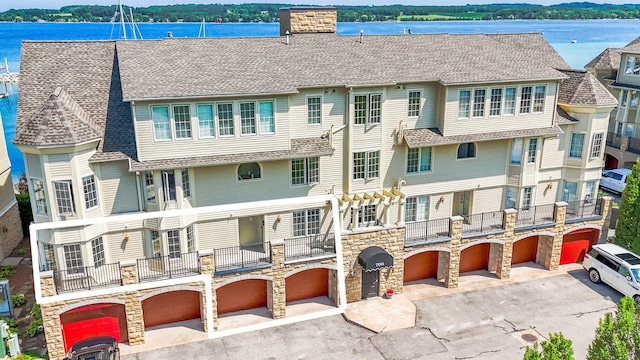 706 N Dockside Cir, Suttons Bay, MI 49682 - view of property featuring a garage, driveway, and a water view
