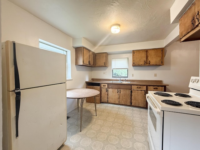 207 W Railroad St, Dowagiac, MI 49047 - kitchen featuring white appliances, brown cabinets, and light countertops