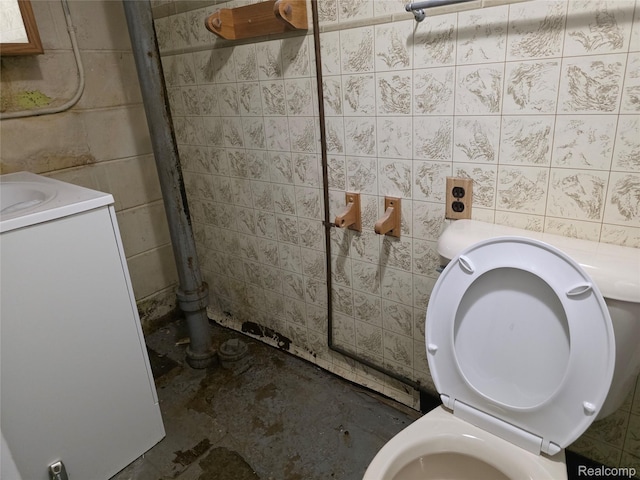 19351 Braile St, Detroit, MI 48219 - bathroom with stacked washing machine and dryer, vanity, unfinished concrete flooring, and concrete block wall