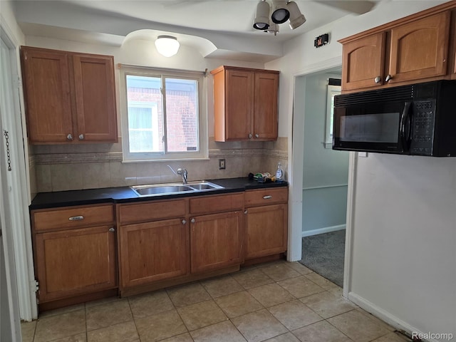 19351 Braile St, Detroit, MI 48219 - kitchen with black microwave, dark countertops, and brown cabinetry