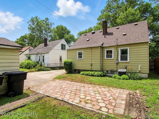1225 S Annabelle St, Detroit, MI 48217 - back of property featuring a chimney and roof with shingles