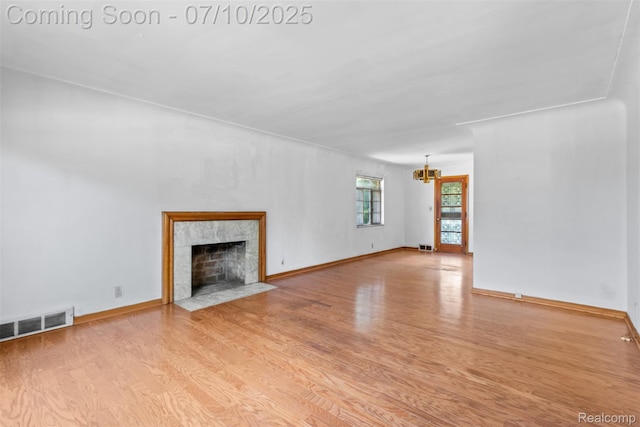 24280 Moritz St, Oak Park, MI 48237 - unfurnished living room featuring wood finished floors, a chandelier, and a tiled fireplace