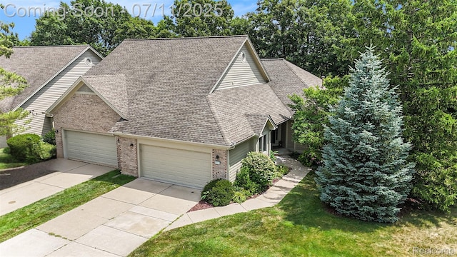 3787 Santa Fe Trl, Ann Arbor, MI 48108 - view of front of house with brick siding, an attached garage, a shingled roof, and driveway