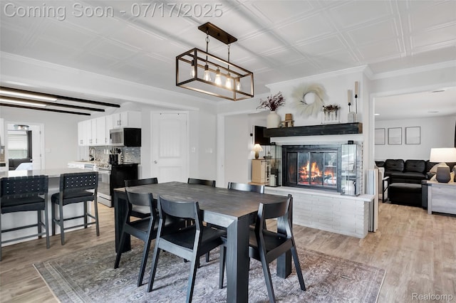 1890 Darwin Rd, Pinckney, MI 48169 - dining area featuring light wood-style floors, a glass covered fireplace, and an ornate ceiling
