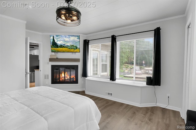 1890 Darwin Rd, Pinckney, MI 48169 - bedroom with wood finished floors, ornamental molding, a glass covered fireplace, and freestanding refrigerator