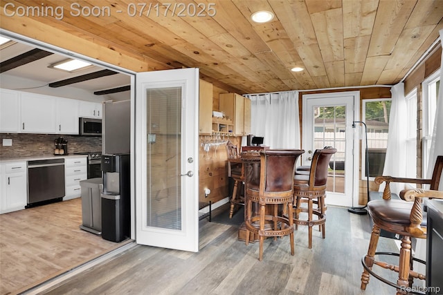 1890 Darwin Rd, Pinckney, MI 48169 - kitchen with light wood-style floors, white cabinets, appliances with stainless steel finishes, decorative backsplash, and wooden ceiling