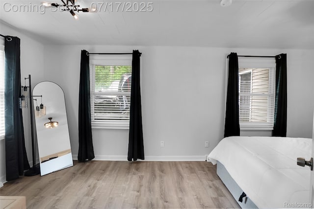 1890 Darwin Rd, Pinckney, MI 48169 - bedroom with light wood-style flooring and a chandelier