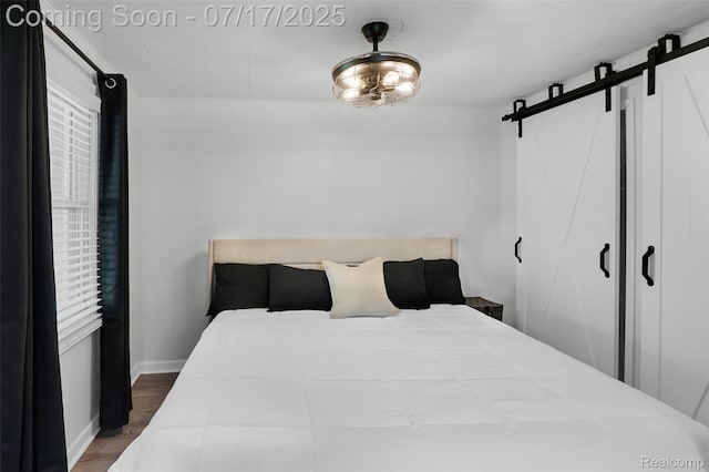 1890 Darwin Rd, Pinckney, MI 48169 - bedroom with a barn door and wood finished floors