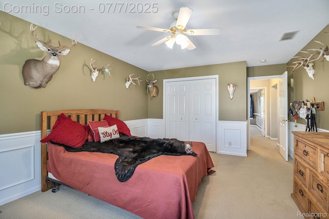 1090 E Jones Rd, Howell, MI 48855 - bedroom featuring wainscoting, light colored carpet, a closet, a ceiling fan, and a decorative wall
