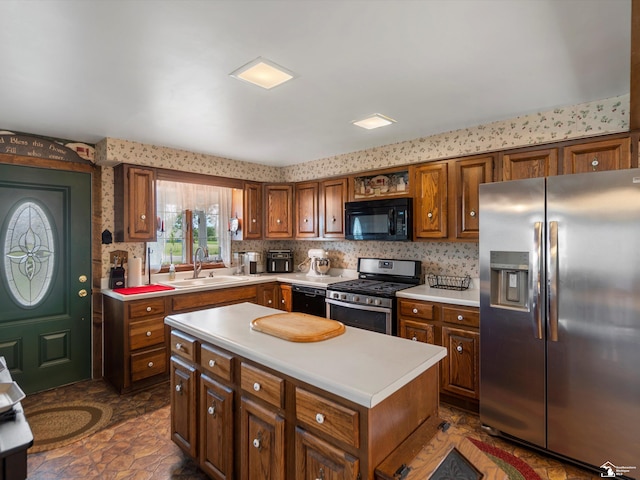 7393 Newport S Rd, Newport, MI 48166 - kitchen with black appliances, light countertops, brown cabinetry, a kitchen island, and backsplash