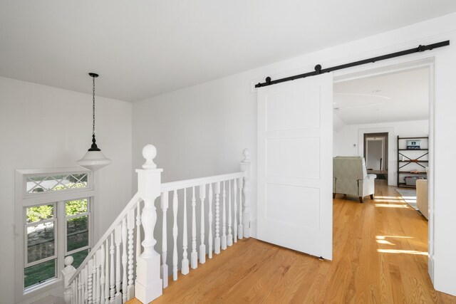 613 E Mitchell St, Petoskey, MI 49770 - corridor with an upstairs landing, a barn door, and light wood-type flooring