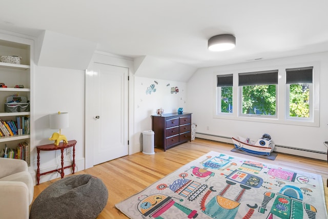 613 E Mitchell St, Petoskey, MI 49770 - bedroom featuring baseboard heating, wood finished floors, and lofted ceiling