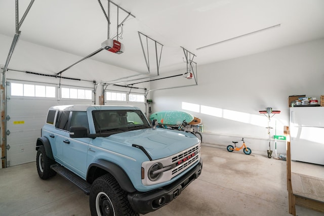 613 E Mitchell St, Petoskey, MI 49770 - garage featuring freestanding refrigerator and a garage door opener