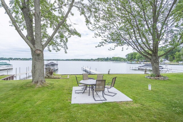 11105 Hahn Beach Dr, Evart, MI 49631 - view of grassy yard featuring a boat dock, a water view, and a patio area