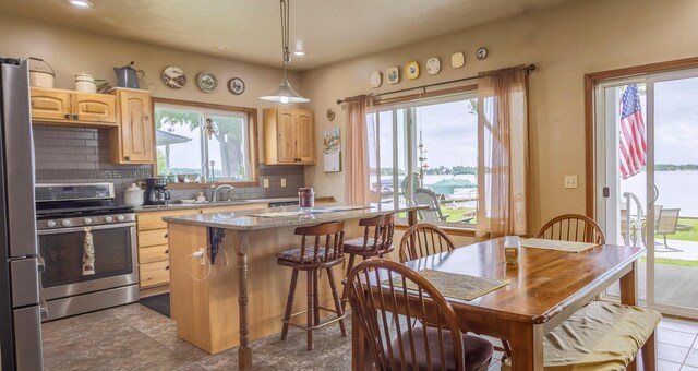 11105 Hahn Beach Dr, Evart, MI 49631 - kitchen with stainless steel appliances, light brown cabinets, tasteful backsplash, a breakfast bar area, and recessed lighting