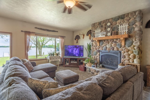 11105 Hahn Beach Dr, Evart, MI 49631 - living area featuring ceiling fan, a stone fireplace, carpet, and a textured ceiling