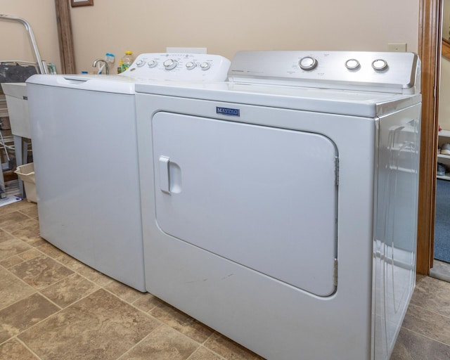 11105 Hahn Beach Dr, Evart, MI 49631 - laundry room with washing machine and clothes dryer and light stone finish flooring