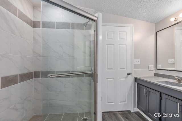 4301 Lasalle Ln, Newaygo, MI 49337 - full bathroom featuring a shower stall, vanity, a textured ceiling, and wood finished floors