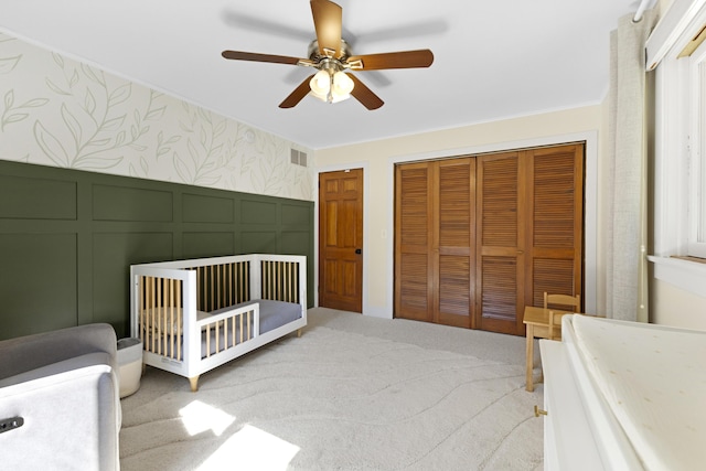 15178 154th Ave, Grand Haven, MI 49417 - carpeted bedroom featuring a decorative wall, two closets, a ceiling fan, a crib, and ornamental molding