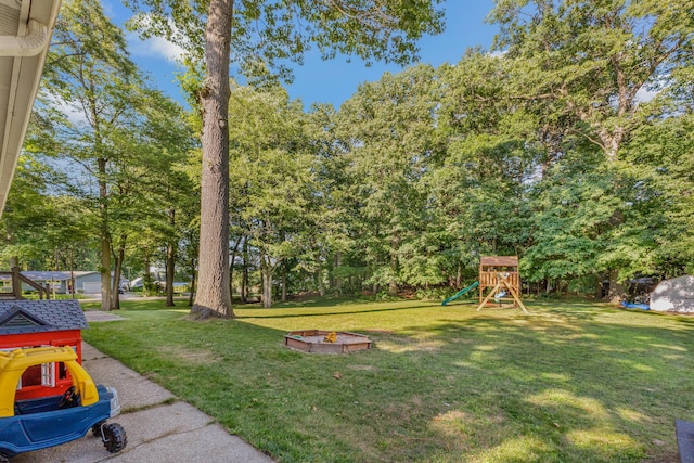 15178 154th Ave, Grand Haven, MI 49417 - view of green lawn featuring a playground, view of scattered trees, and a fire pit