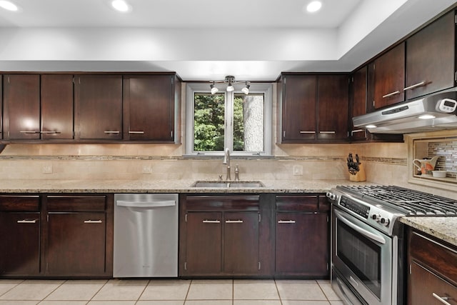 15178 154th Ave, Grand Haven, MI 49417 - kitchen featuring stainless steel appliances, under cabinet range hood, light tile patterned flooring, light stone countertops, and decorative backsplash