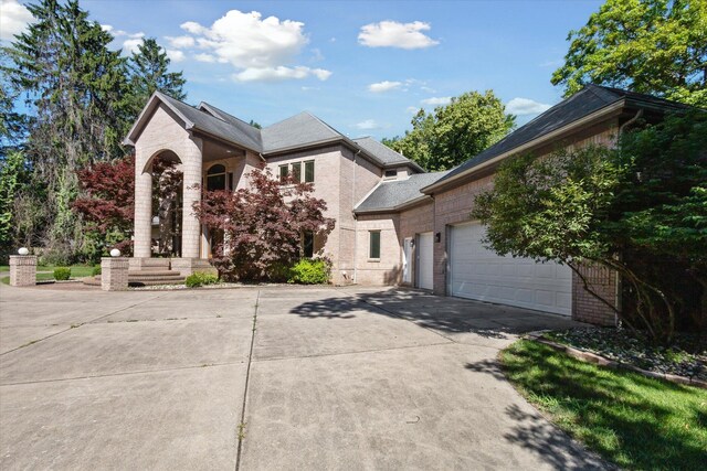 6076 Browns Lake Rd, Jackson, MI 49203 - view of front facade with driveway, brick siding, and an attached garage