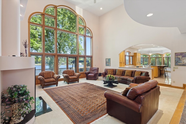 6076 Browns Lake Rd, Jackson, MI 49203 - living area featuring a high ceiling, arched walkways, recessed lighting, healthy amount of natural light, and a water view