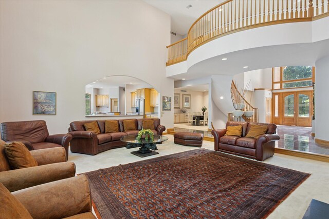 6076 Browns Lake Rd, Jackson, MI 49203 - living area with a high ceiling, arched walkways, stairway, and light carpet