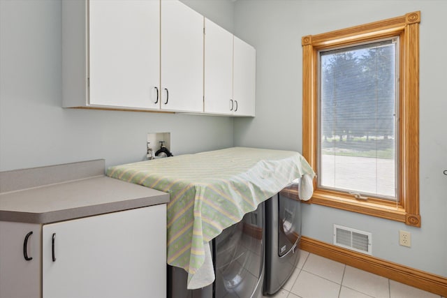 6076 Browns Lake Rd, Jackson, MI 49203 - laundry area featuring cabinet space, washing machine and clothes dryer, and light tile patterned floors
