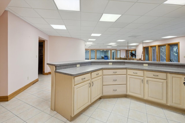 6076 Browns Lake Rd, Jackson, MI 49203 - kitchen featuring cream cabinetry, light tile patterned floors, dark countertops, and a paneled ceiling