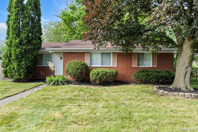 42078 Arthur St, Belleville, MI 48111 - view of front of home featuring brick siding, a front yard, and a shingled roof