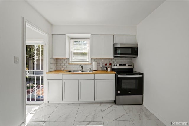 18247 Harlow St, Detroit, MI 48235 - kitchen featuring stainless steel appliances, light marble finish flooring, decorative backsplash, and white cabinets