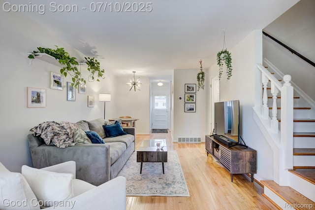 323 W Lincoln Ave, Royal Oak, MI 48067 - living area with stairs, light wood finished floors, and a chandelier