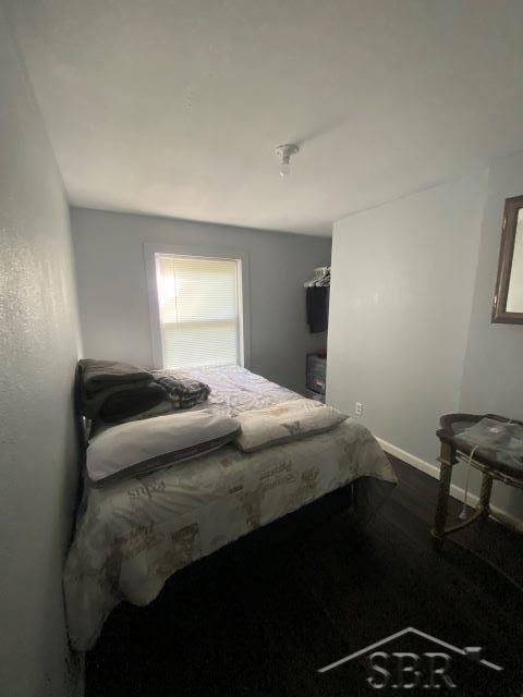 142 W Mason Rd, Twining, MI 48766 - bedroom featuring baseboards and dark wood-style floors