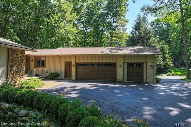 7500 Deerhill Dr, Clarkston, MI 48346 - view of front facade featuring a garage, asphalt driveway, and brick siding