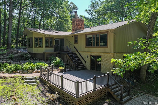 7500 Deerhill Dr, Clarkston, MI 48346 - back of property with stairway, a wooden deck, brick siding, and a chimney