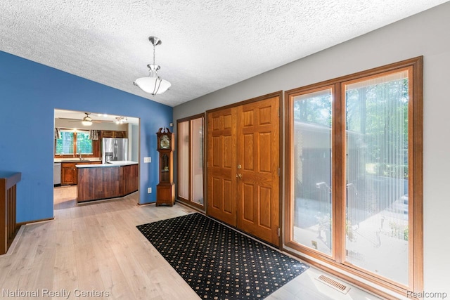 7500 Deerhill Dr, Clarkston, MI 48346 - foyer entrance featuring light wood finished floors and a textured ceiling
