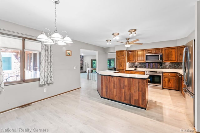 7500 Deerhill Dr, Clarkston, MI 48346 - kitchen featuring stainless steel appliances, healthy amount of natural light, brown cabinets, and decorative backsplash
